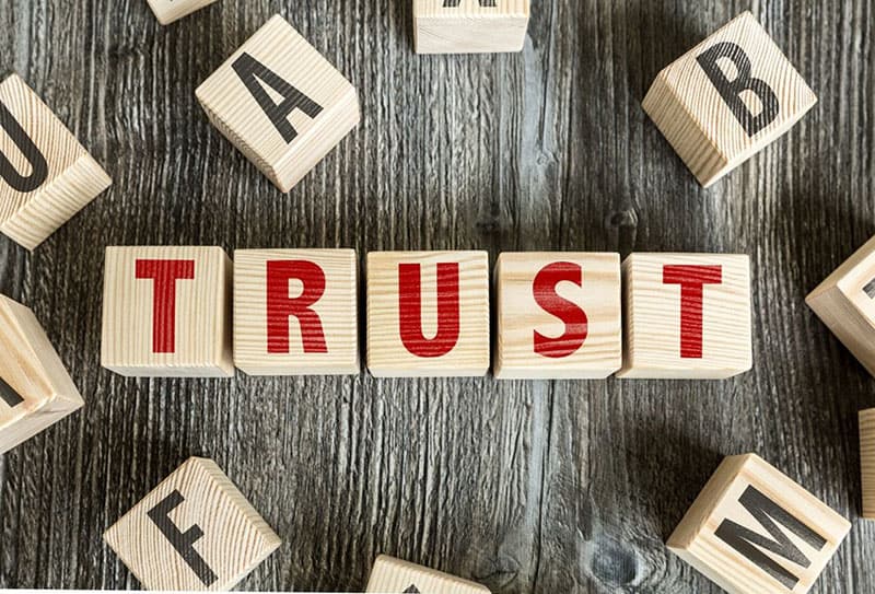 the word trust formed from the letter blocks along with some letters