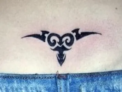 Tribal Aries tattoo on the lower back