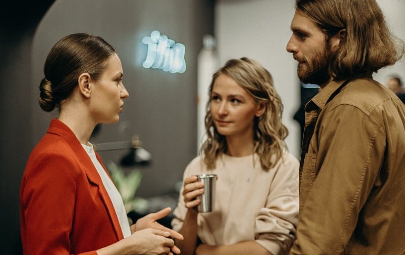 Two women and one man talking