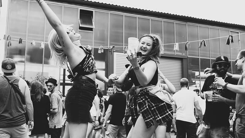 two women dancing outside of building at the party