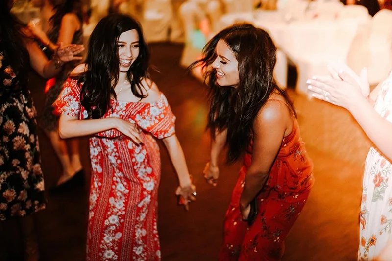 two women in red dresses dancing on the floor