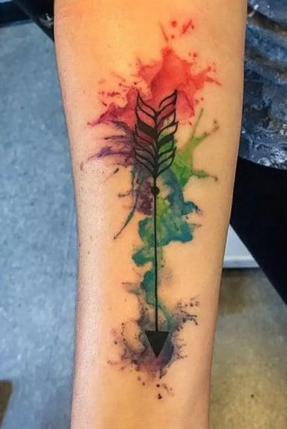 watercolor splash arrow tattoo inside of the arm