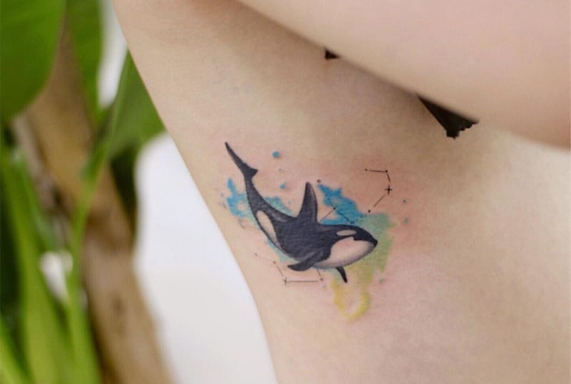 watercolour orca and constellation tattoo on the rib side