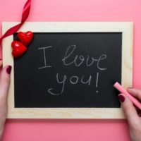 Woman hands I love you message on chalkboard
