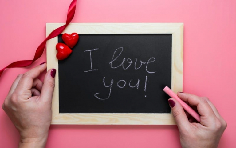 Donna consegna un messaggio d'amore su lavagna