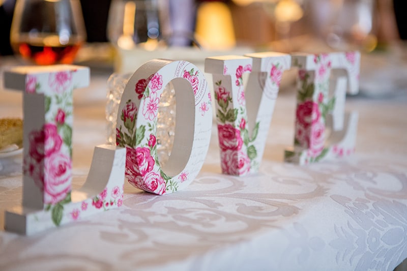 white and pink floral free standing letter decor on the table