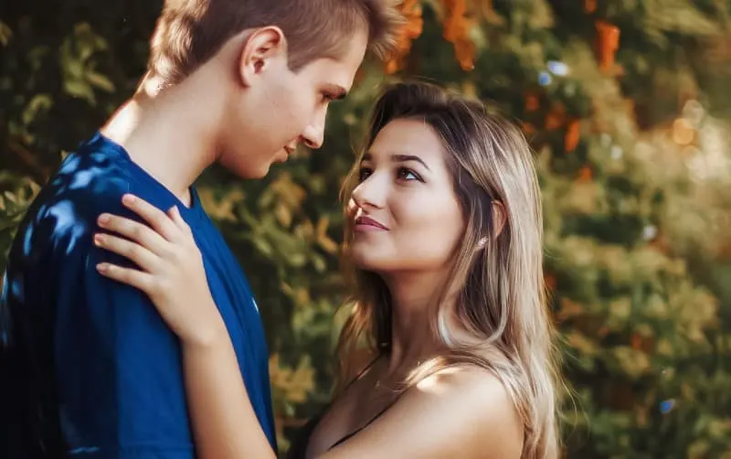 woman and man standing face to face very close to each other outdoors during daytime