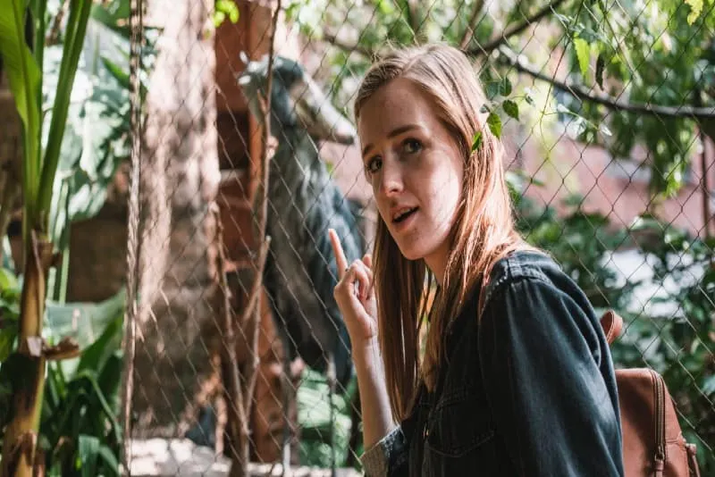 woman wearing brown backpack at zoo
