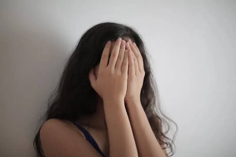 woman covering her face with her hands