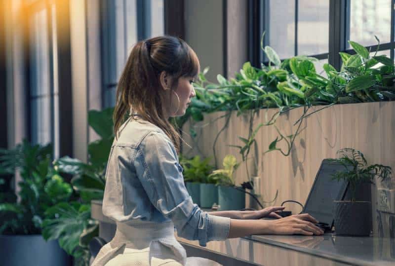 Donna che compila una domanda con un computer portatile in un ufficio moderno