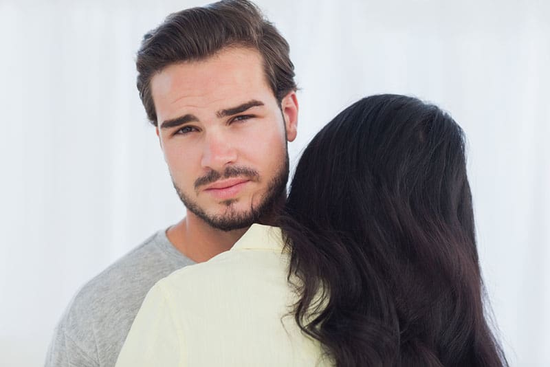 woman giving a hug to unintrested man