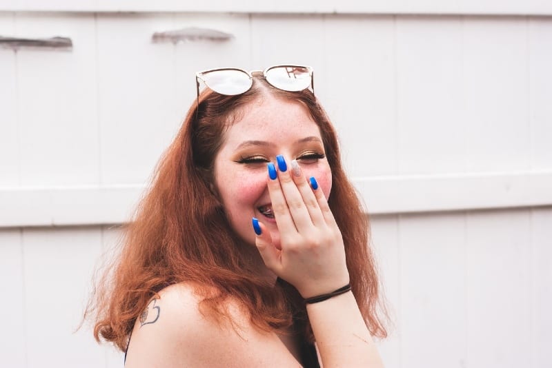 woman hiding her laugh with her hand
