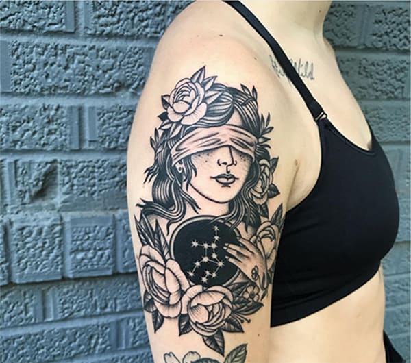woman holding a disk with constellation tattoo on the arm