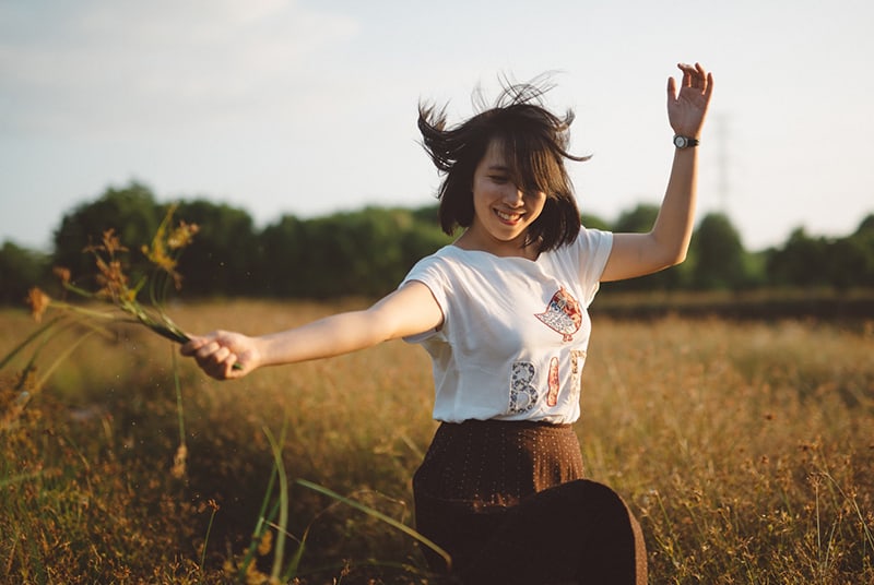 woman holding flower on the field