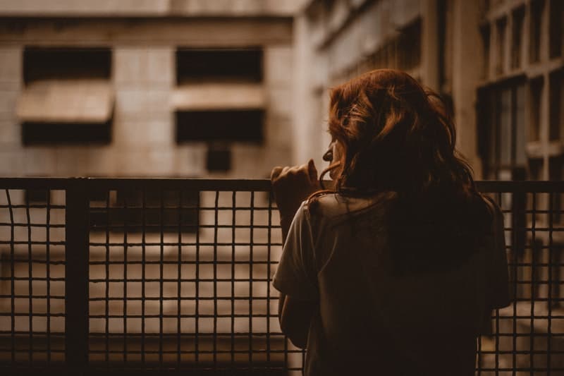 woman holding on railings leaning in sepia color