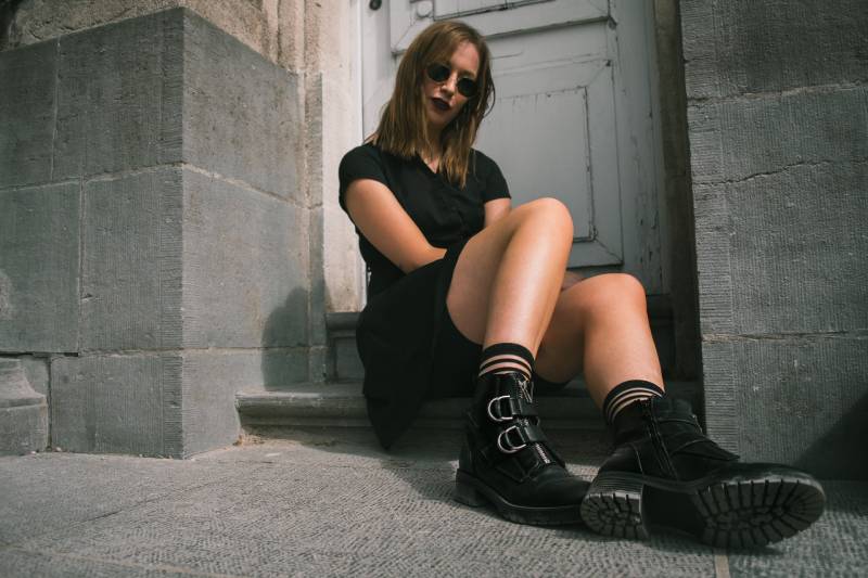 mujer con vestido negro sentada delante de una mesa