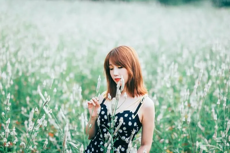 woman in black floral dress in green field