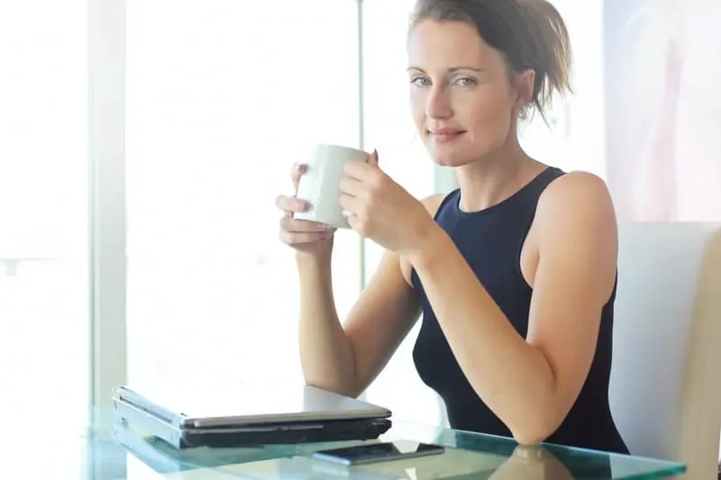 woman in black top drinking coffee