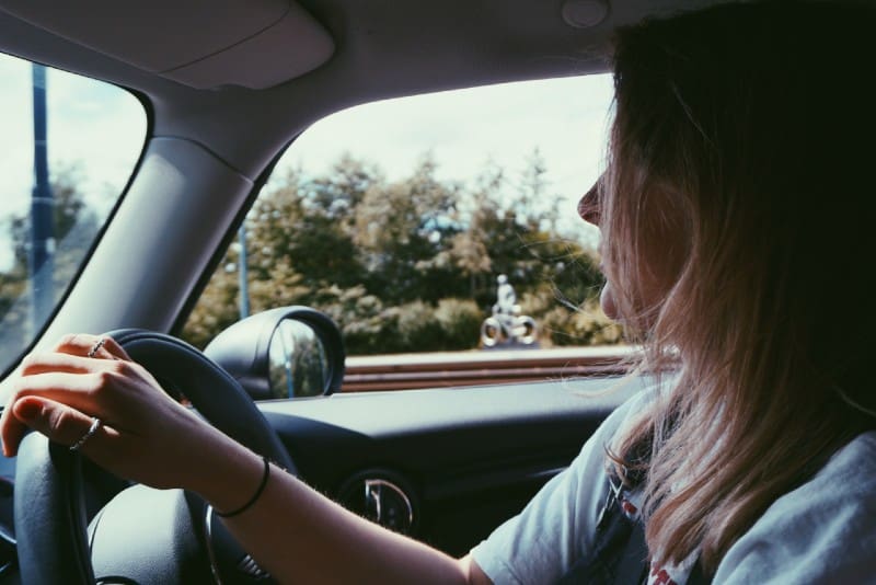 woman holding steering wheel in car