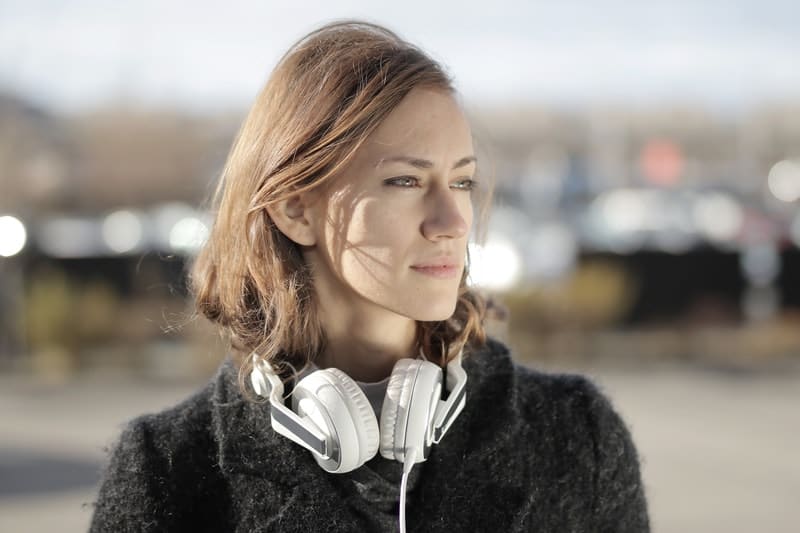 woman in coat wearing headphones