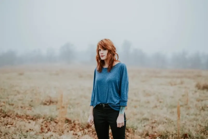 woman in blue top standing in field