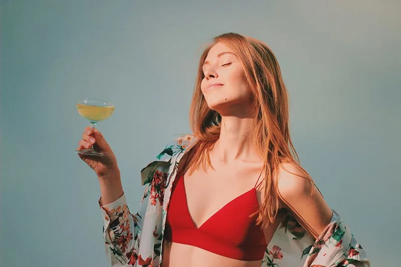woman in red bikini top holding champagne glass