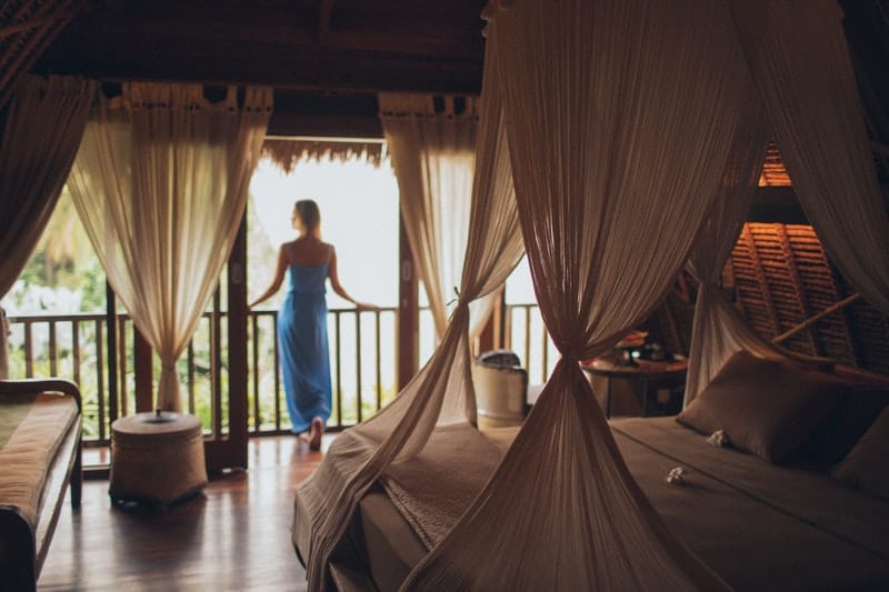 woman inside a villa room standing near the window