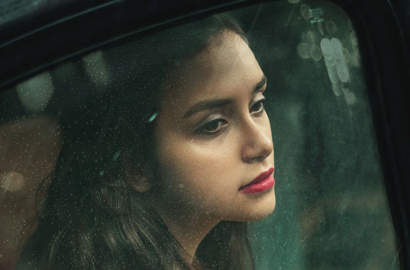 woman inside the car looking sad