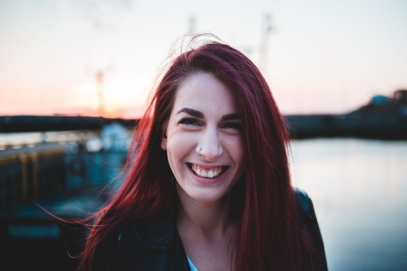 mujer pelirroja riendo al aire libre