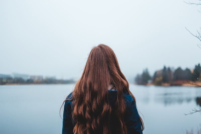 woman with long hair looking at water