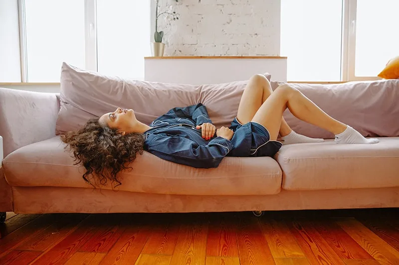 woman lying on couch during daytime