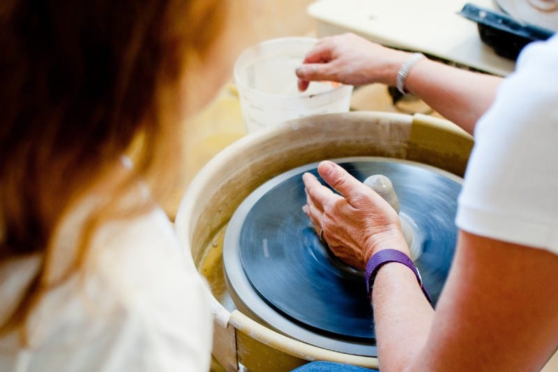 woman in white shirt making pottery