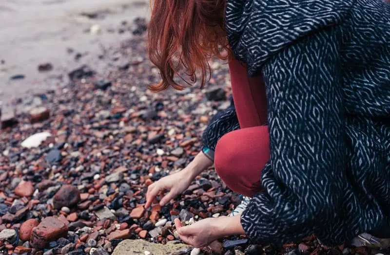 woman picking stones of different colors in a side shot
