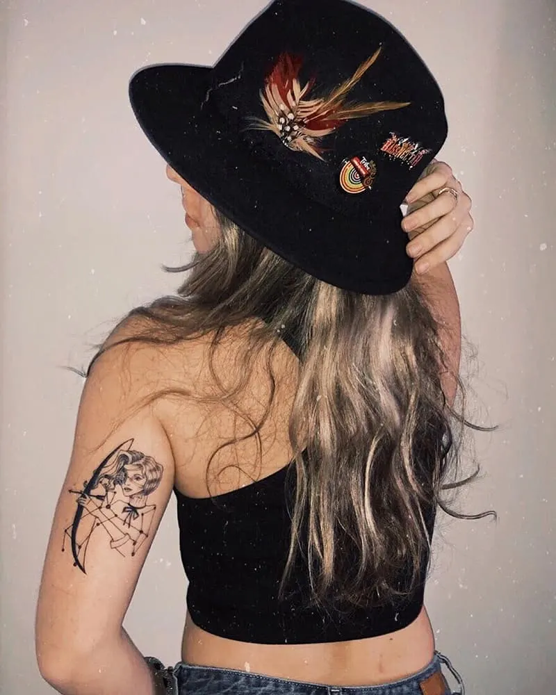 woman shooting an arrow tattoo on back of the arm