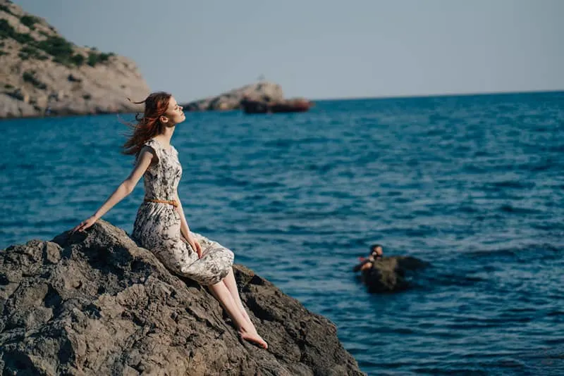 woman sitting by the sea
