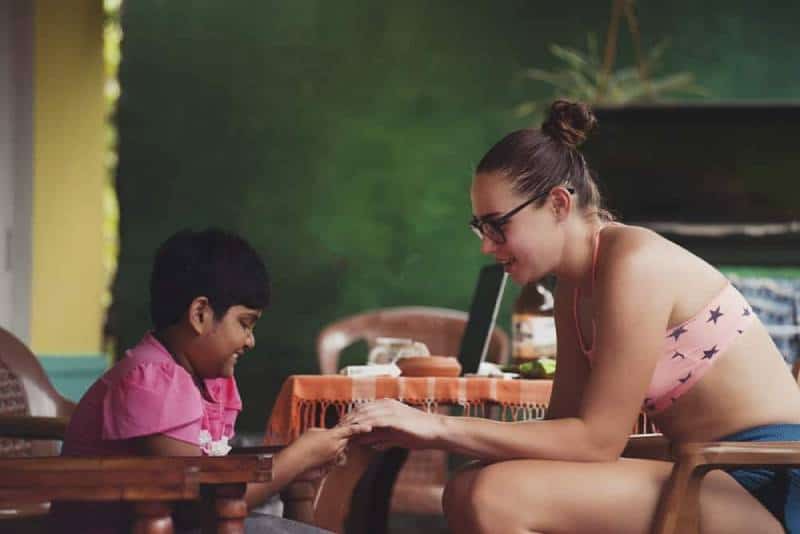 woman sitting holding childs hand