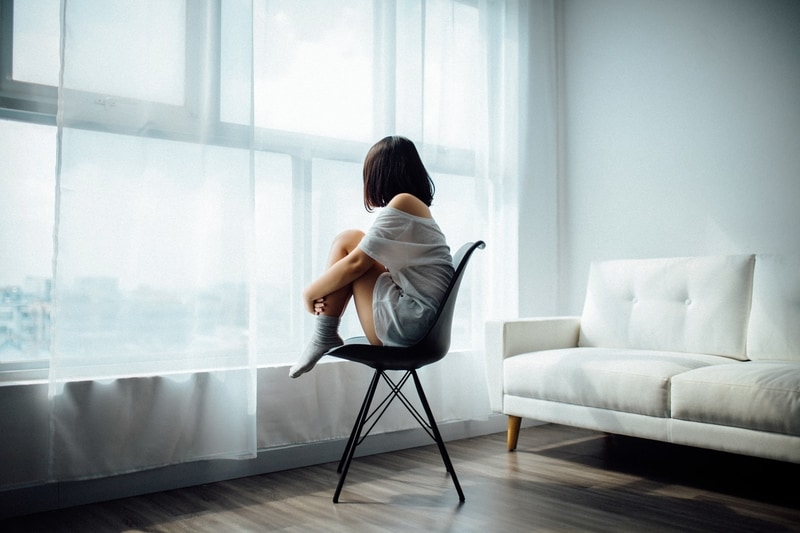 woman sitting on black chair near window
