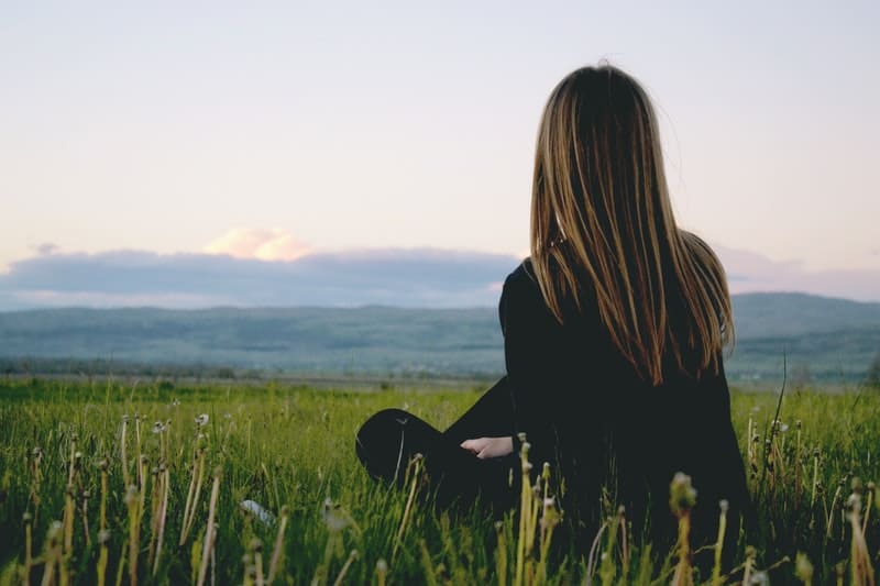 woman sitting on green grass wearing longsleeves