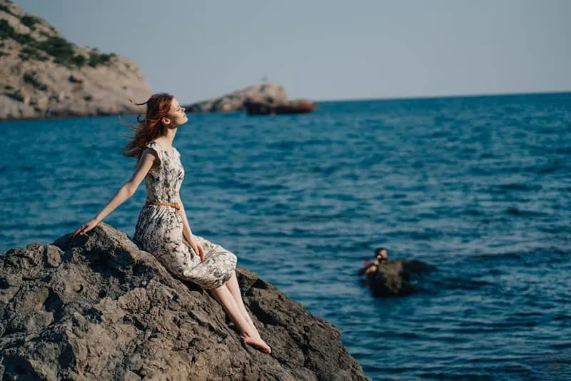 woman sitting on the rock in the sea