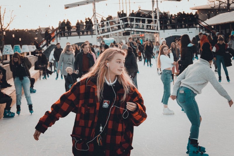 woman in checked jacket ice skating during day