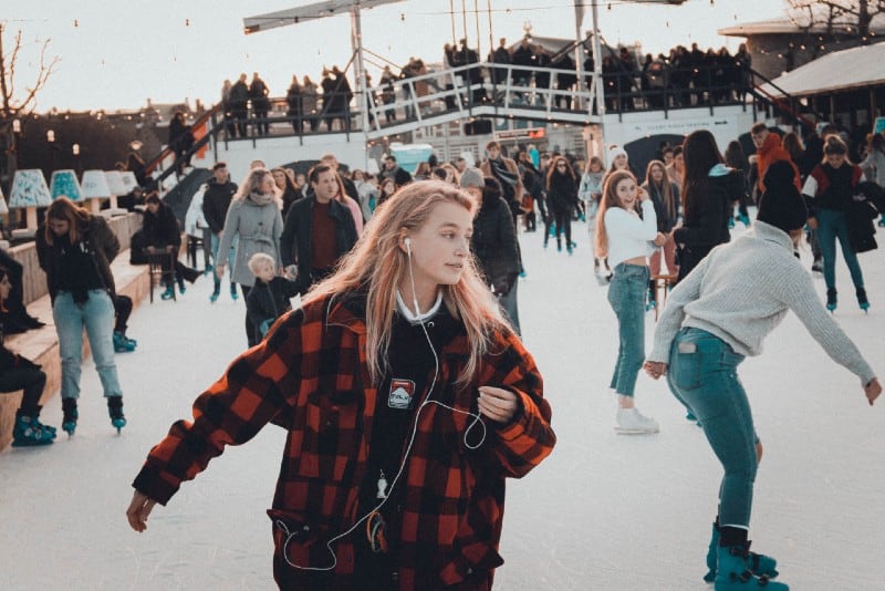 mujer con chaqueta a cuadros patinando sobre hielo durante el día