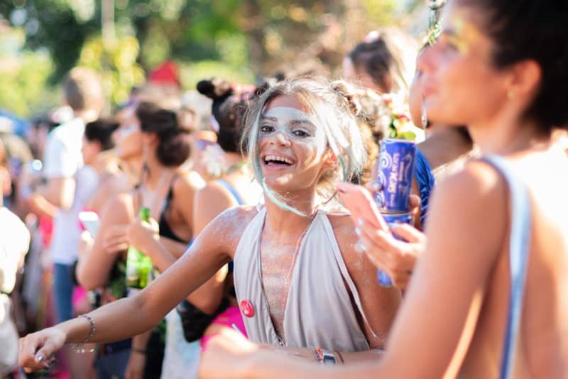 woman with face covered in paint smiling