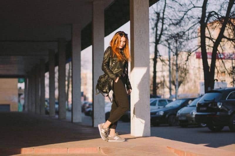 mujer de pie junto al pilar de un edificio