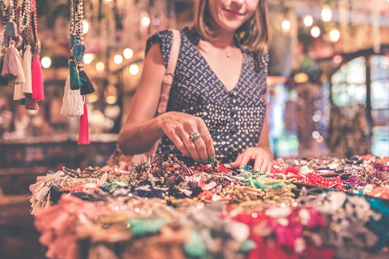 mujer de pie junto a una mesa llena de accesorios