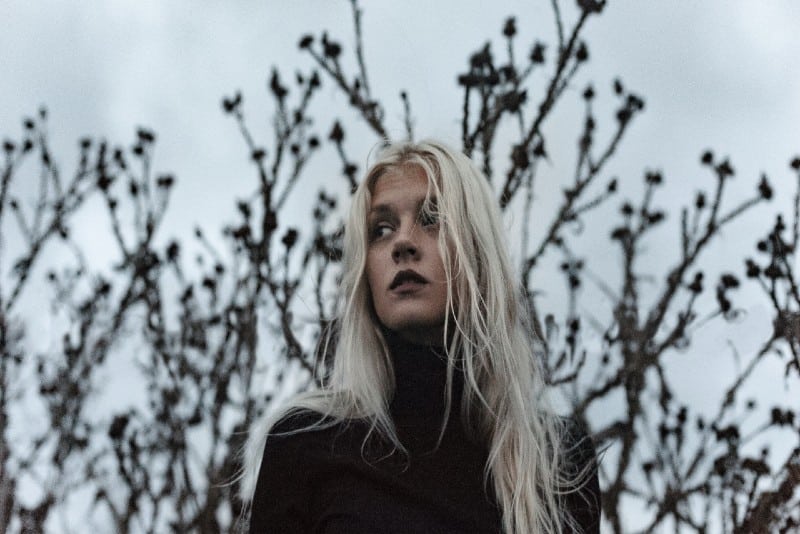 woman wearing black turtleneck sweater standing near tree