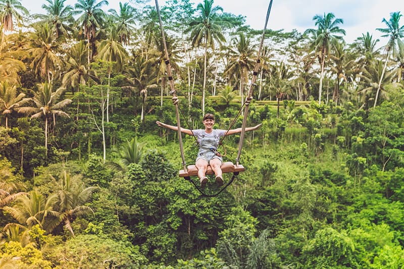 woman swinging on the cliff in the jungle