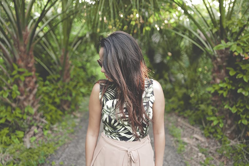 mulher a caminhar num trilho florestal olhando para baixo