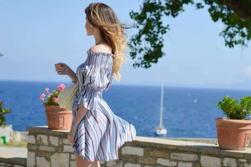 mujer con vestido mirando al mar