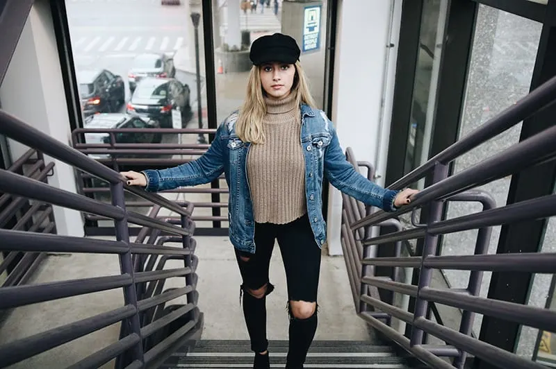 woman wearing blue denim jacket standing in the stairs
