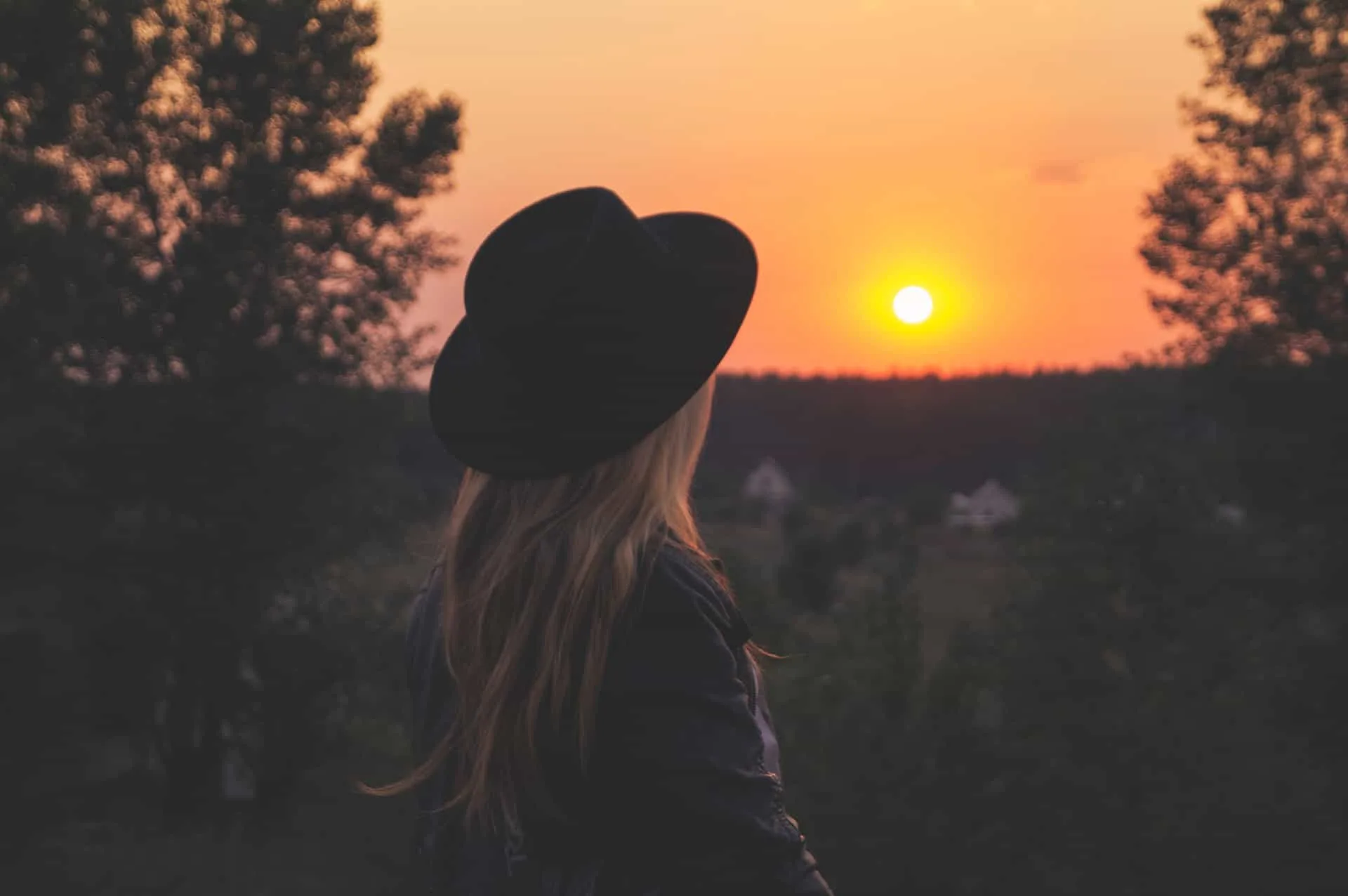 woman wearing hat on sunset